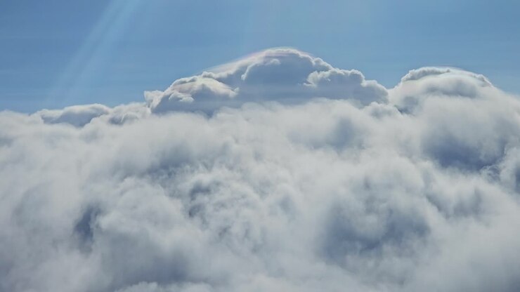 The footage, taken from a steady vantage point, reveals a stunning panorama where the sunlight glistens over the undulating cloudscape