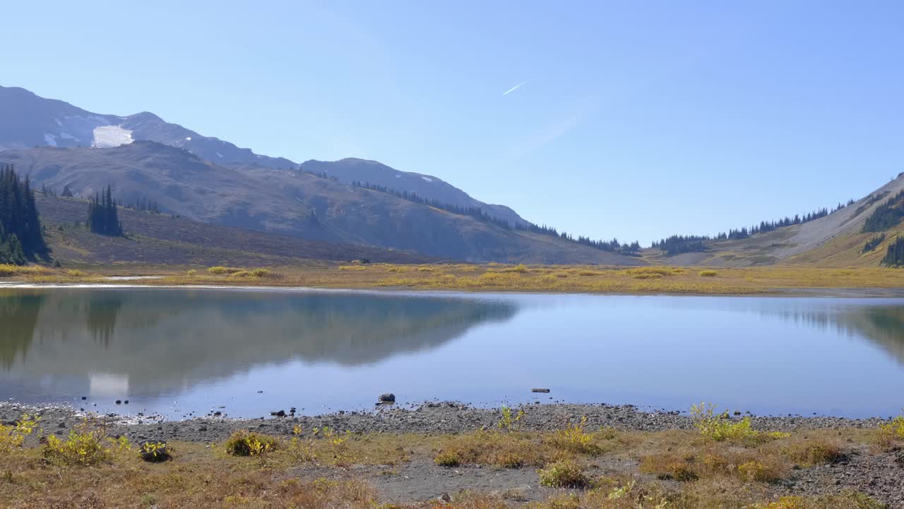 отражение гор на спокойном озере во время восхода солнца