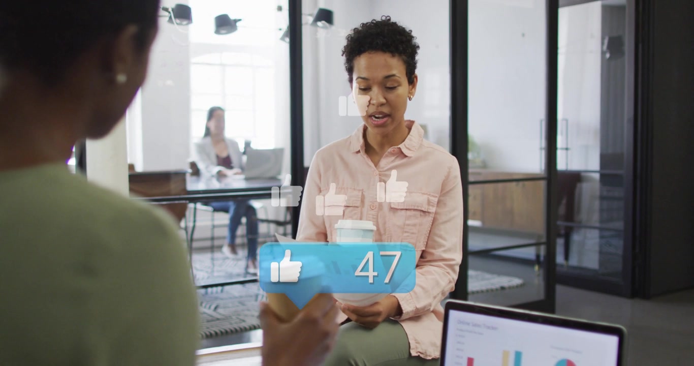 Seated office woman talking while peer giving cup, blue like counter rising around torso for likes