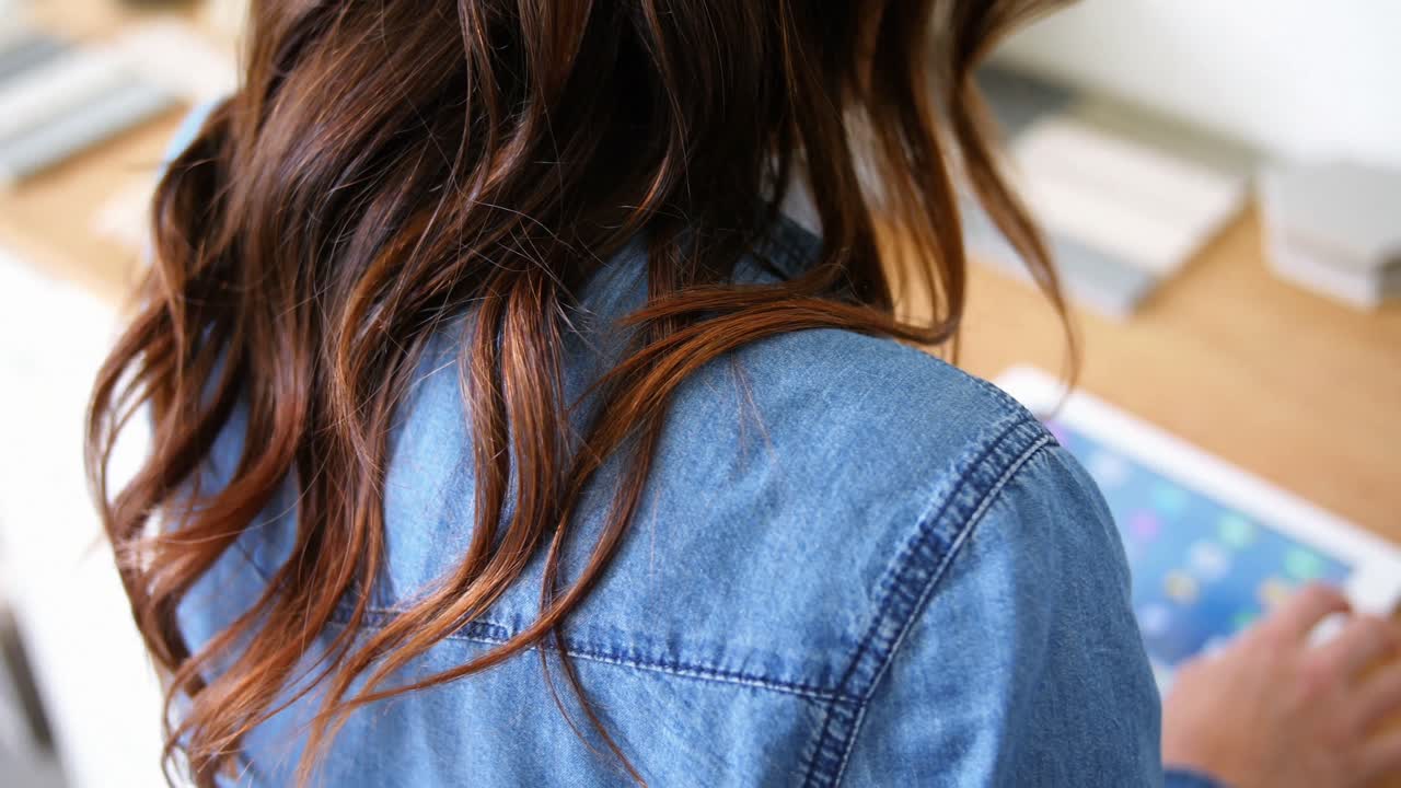 책상 에 앉아 디지털 태블릿 을 사용하는 여성 임원