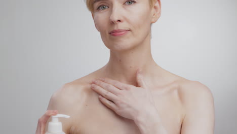 woman applying lotion to chest