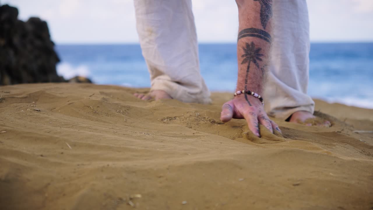 A contemplative moment as sand slips through a person’s fingers, symbolizing mindfulness, time, and the fleeting beauty of nature by the sea under calm daylight