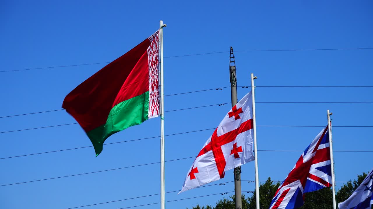 Flags of Belarus, Georgia, Great Britain and Israel on flagpoles
