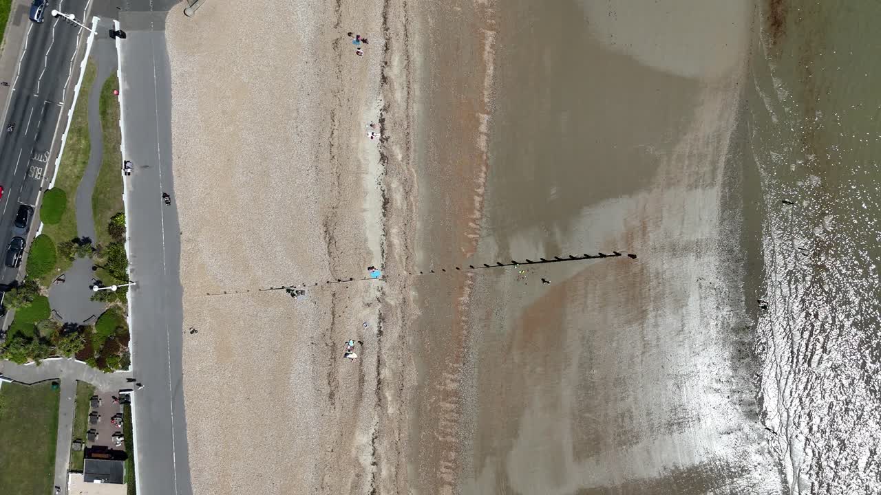 Vista aerea con drone di spiaggia e frangiflutti, con il drone in ascesa.