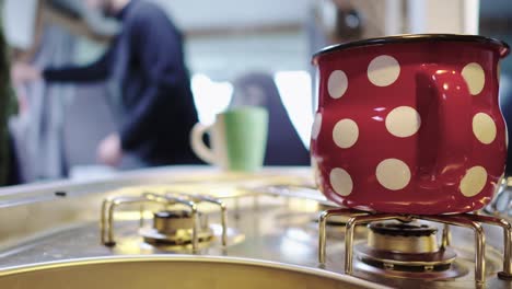 steaming mug on cooker or stove in campervan kitchen, person in blurry background