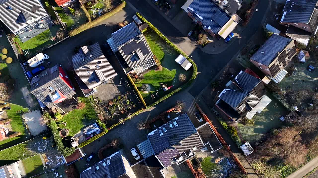 Aerial top down of housing area with solar panels on roof. Sunny day in rural countryside during sunny day. Frosty winter day in USA. Flyover shot.