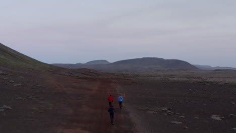 Drone-view-of-three-hiker-walking-pathway-enjoying-spectacular-panorama-of-iceland-highlands.-Birds-eye-of-tourist-exploring-moonscape-wild-countryside