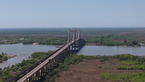 aerial view of justo josé de urquiza bridge over the paraná guazú river surrounded by green and brown landscape