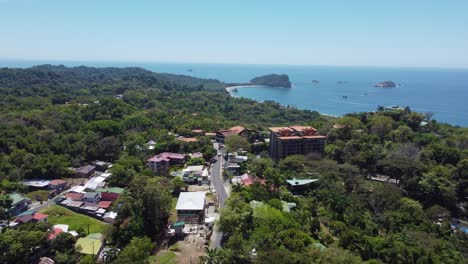 Manuel-Antonio,-Costa-Rica,-cityscape-nestled-among-the-lush-greenery-of-tropical-trees,-and-the-azure-waters-of-the-Pacific-Ocean-stretching-out-in-the-distance