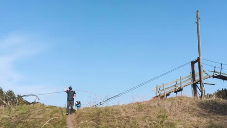 man walking on a hill with an old cable car structure