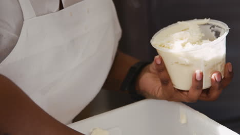 Woman-preparing-frosting-to-use-on-muffins-at-a-bakery