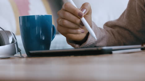 close up woman hands using tablet computer with stylus pen browsing social media checking emails on mobile touchscreen device relaxing at home