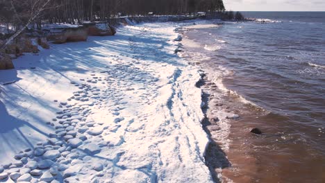 drone flight over the sea in winter frozen rocks on the coast