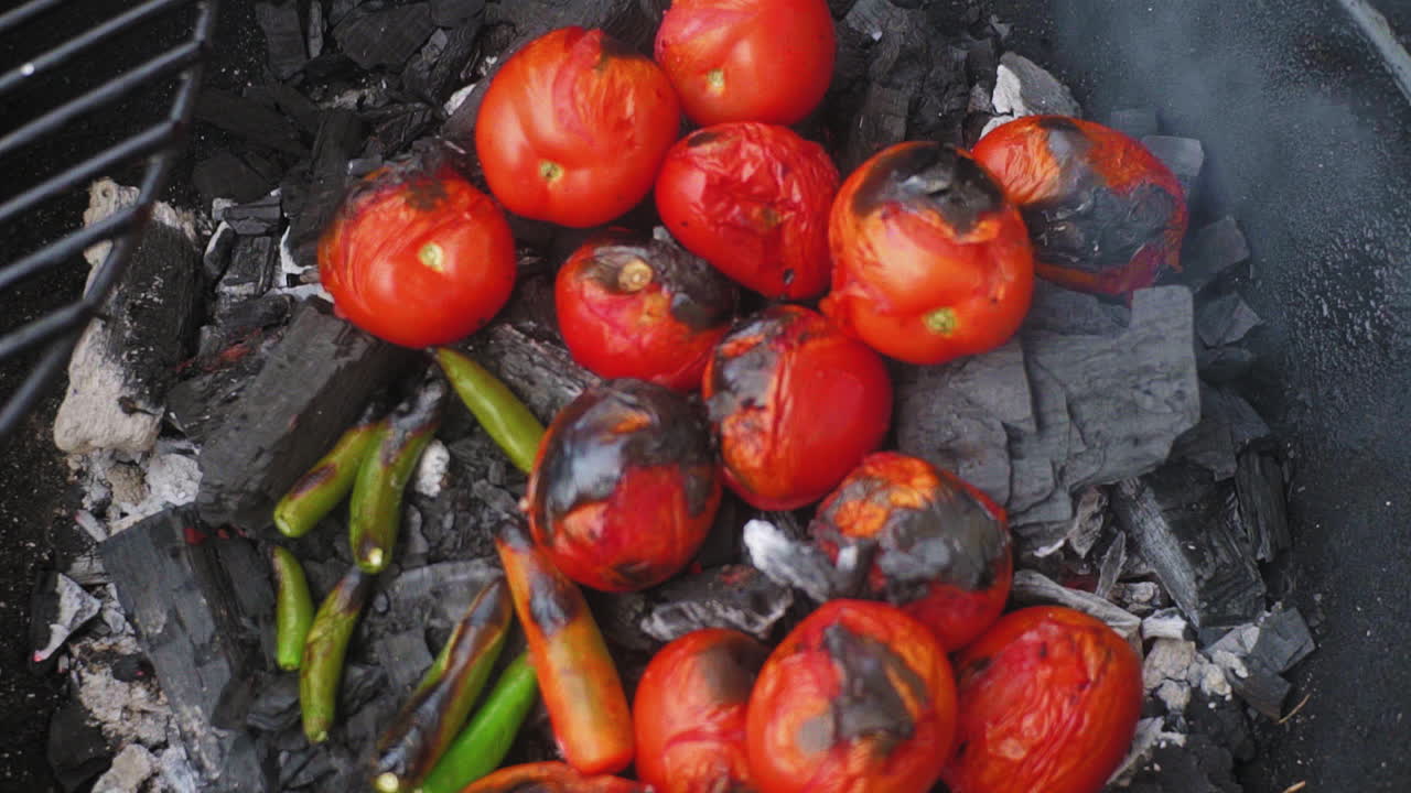 고추로 둘러싸인 바비큐에 있는 토마토의 하향식 샷