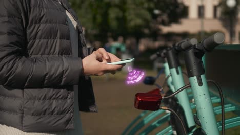 mujer usando una aplicación para desbloquear un scooter eléctrico