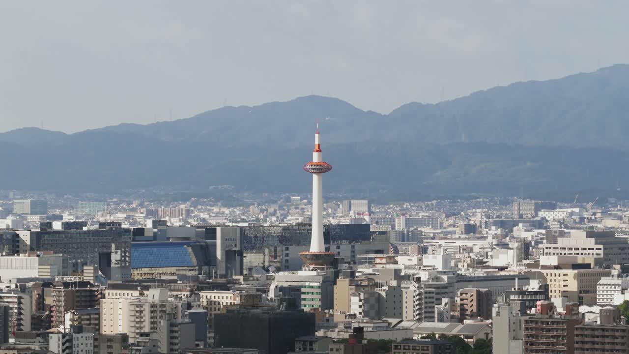 Aerial tilt up Japan Kyoto Tower, famous iconic landmark, urban town buildings