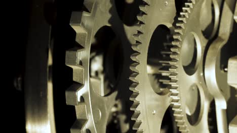 close up cogwheels of an industrial looking clock backlight