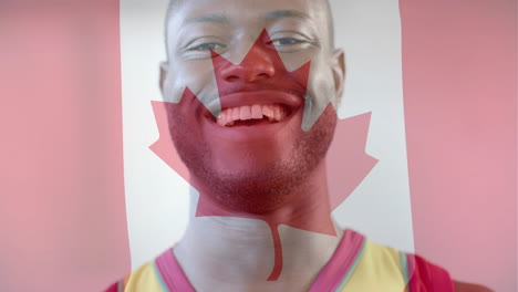 animación de la bandera de canadá sobre un jugador de baloncesto afroamericano en el gimnasio