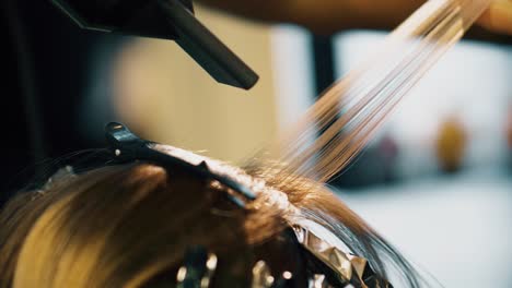 hairstylist using blow dryer to apply heat. drying hair. hair colouring with foil.