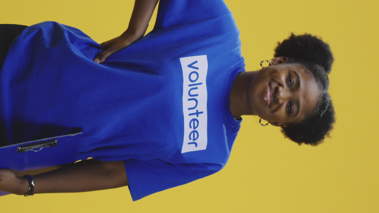 Woman in volunteer shirt on yellow background