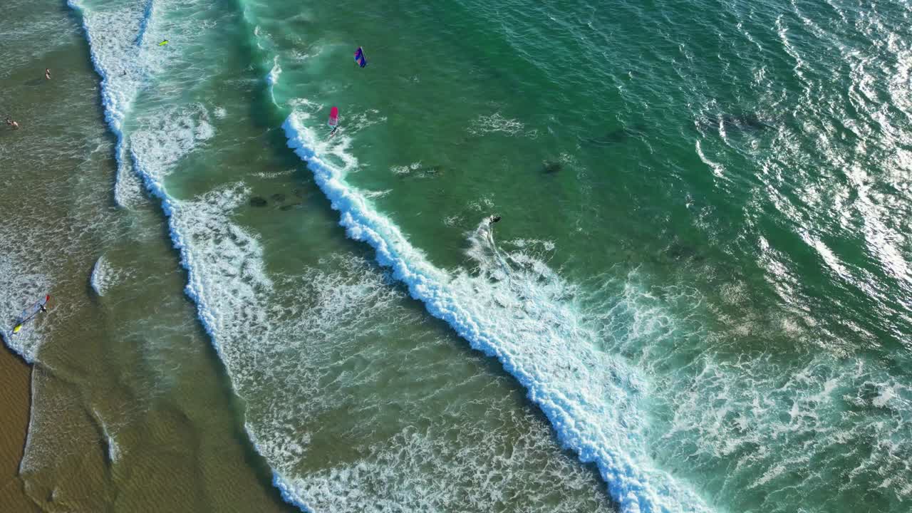 Bird's eye view of the sea from Guincho beach, where kitesurfers are doing maneuvers and the waves are breaking,Cascais,Portugal