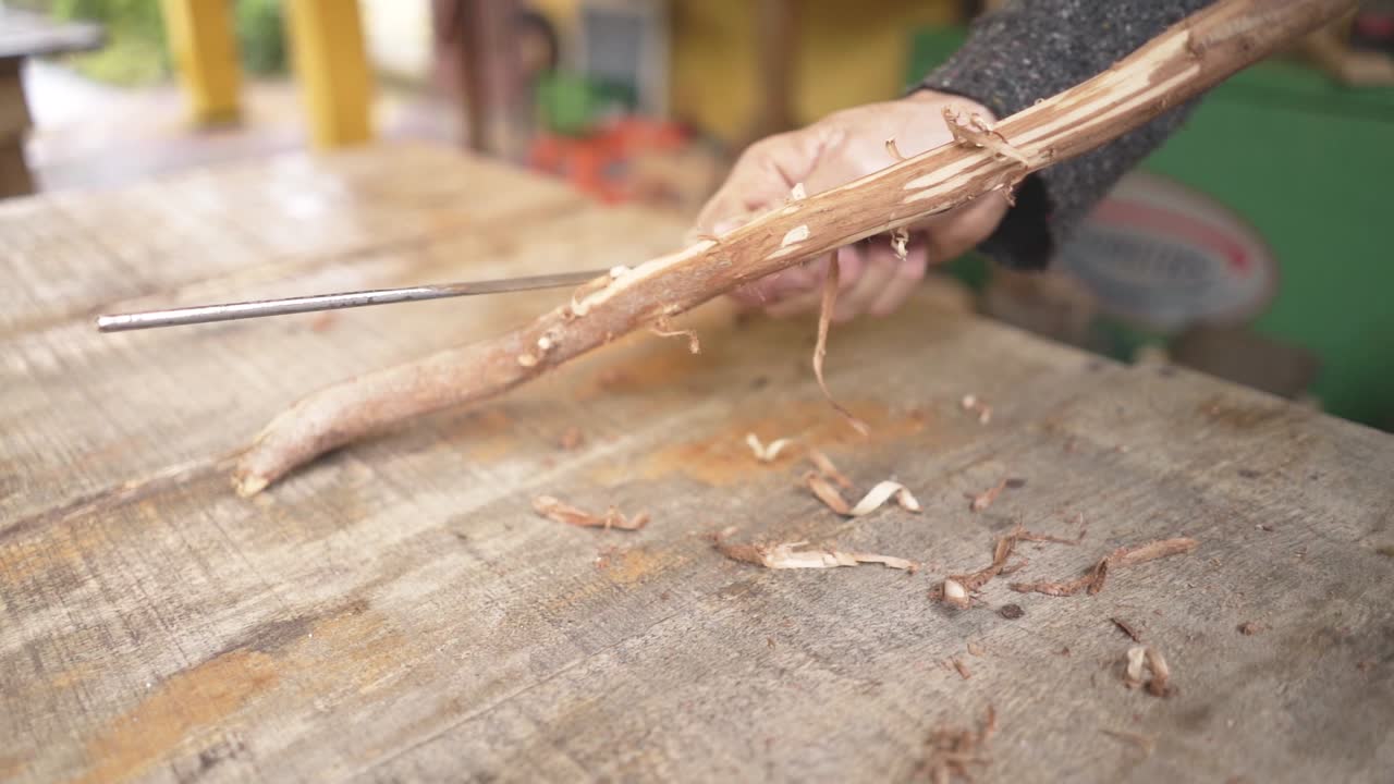 Carpenter peeling a wood in carpentry shop