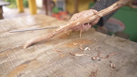 carpenter peeling a wood in carpentry shop