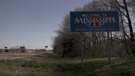 Welcome-to-Mississippi,-birthplace-of-America's-music,-state-line-sign-on-the-side-of-the-freeway-with-stable-video