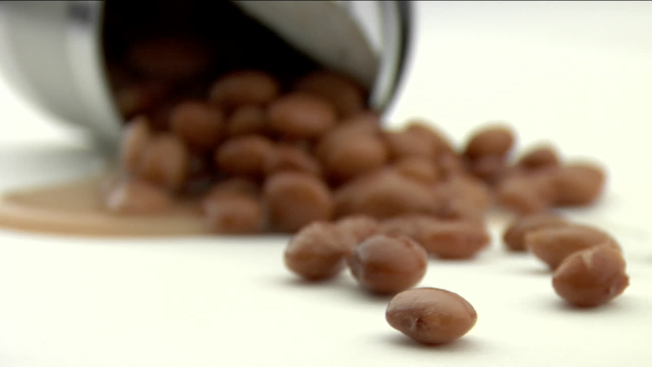 Fagioli rovesciati giacciono su un pavimento bianco 1.