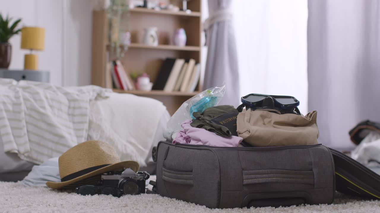 maleta abierta en el dormitorio en casa siendo empacada para las vacaciones de verano 4