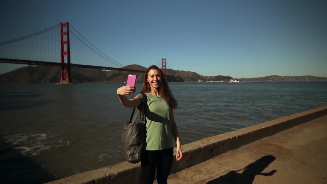 mujer tomando una selfie con el puente golden gate