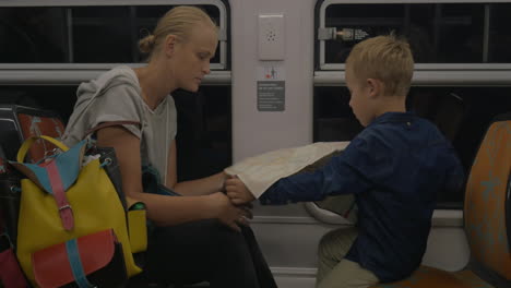 mother and son looking at map in the train