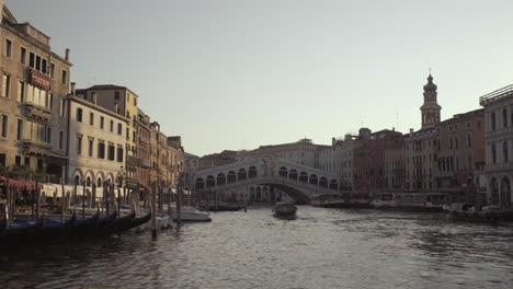 wide shot of ponte di rialto bridge, gondolas and surrounding buildings in morning light, venice, italy