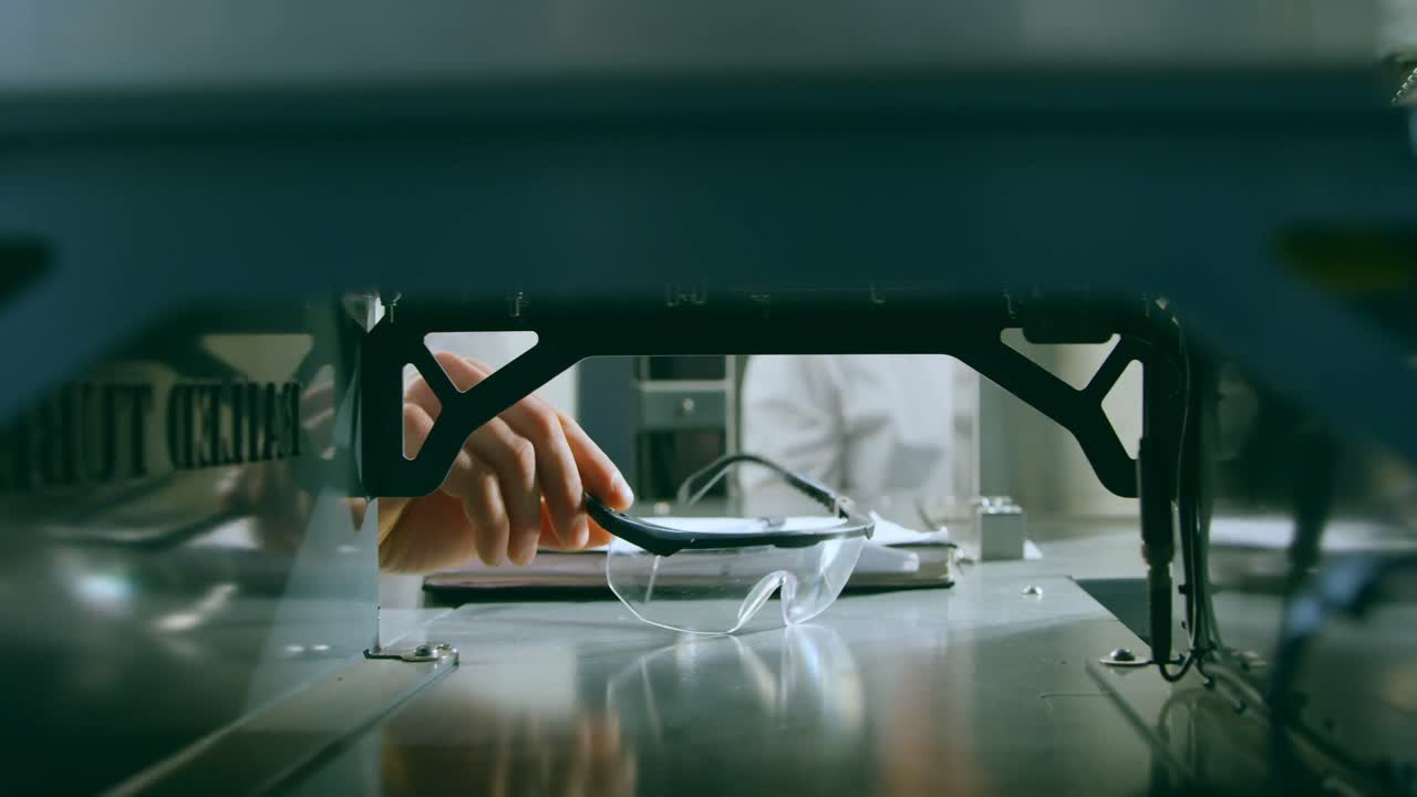 primer plano del ingeniero recogiendo gafas de protección 4k