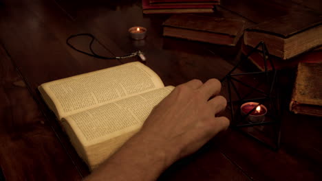 a man is reading a book, drinking wine from a glass