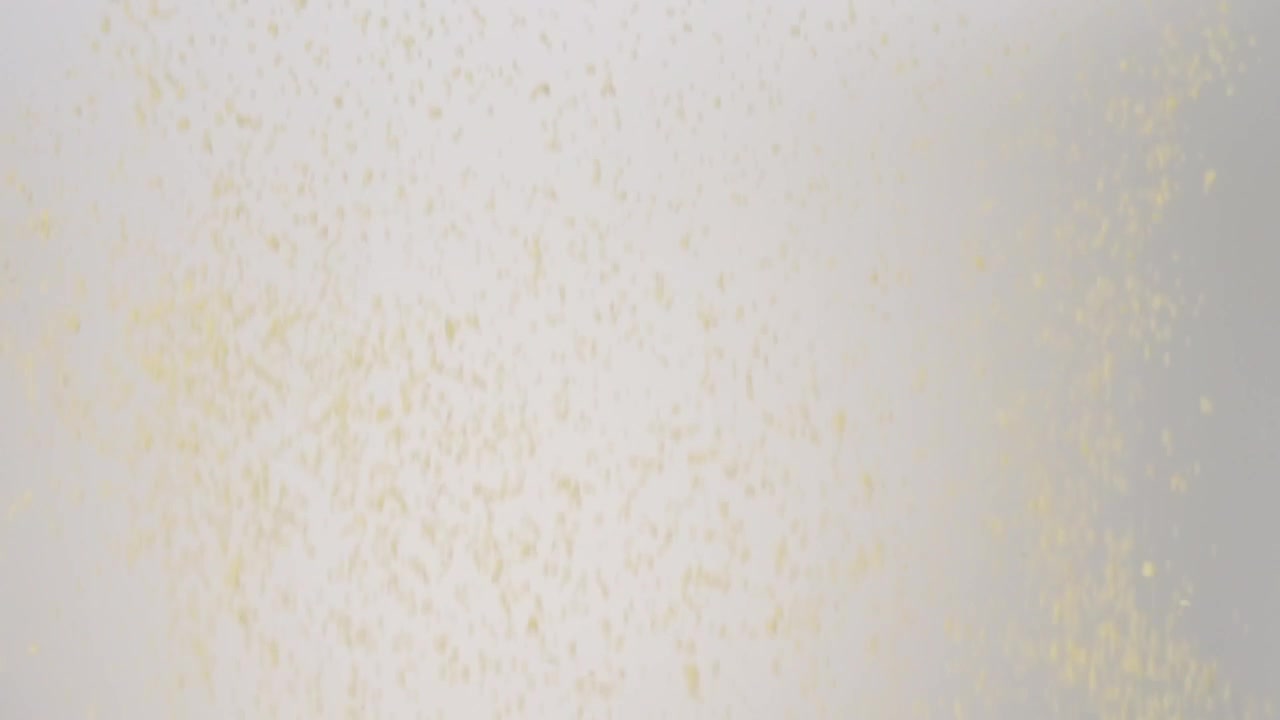 Dry uncooked Couscous raining down on a white backdrop in slow motion close up macro.