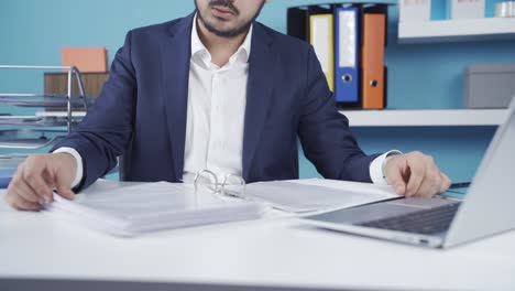 joven hombre de negocios navegando por carpetas de archivos trabajando en una computadora portátil.