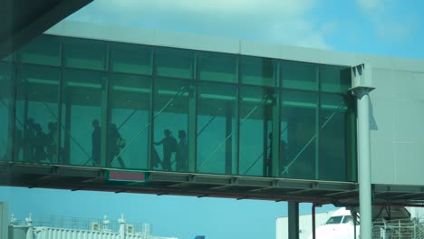 la gente sale del avión por el puente del jetway.