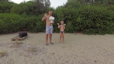 Happy-dad-and-son-waving-hands-to-copter-camera