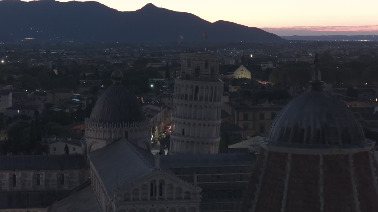 Cinematic sunrise drone footage of the Leaning Tower of Pisa and the Piazza dei Miracoli, captured with smooth aerial movements and soft early morning light