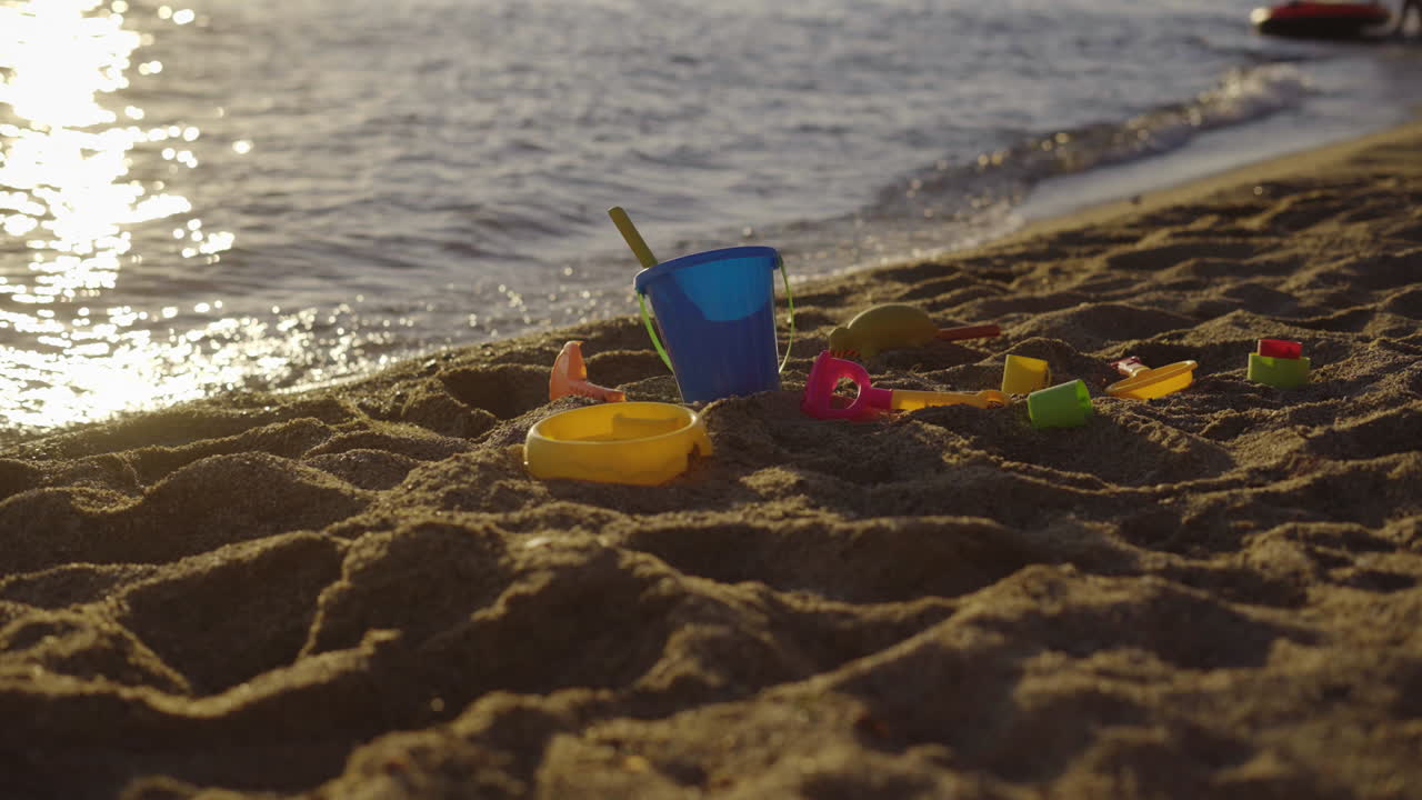 Kids' sand toys on the beach at sunset