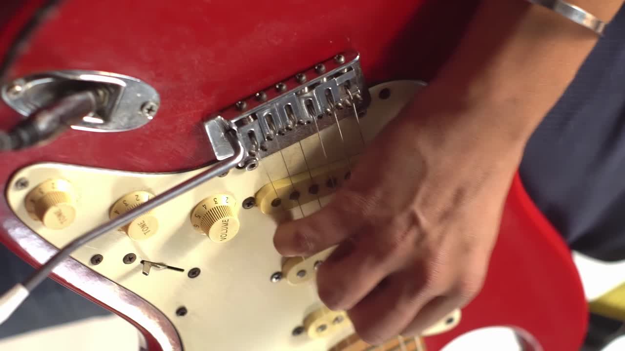 Kırmızı bir elektro gitar çalan adam
