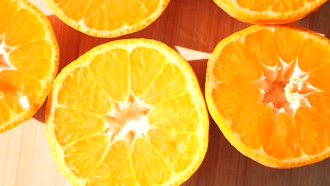 close-up of bright halved oranges on a wooden surface