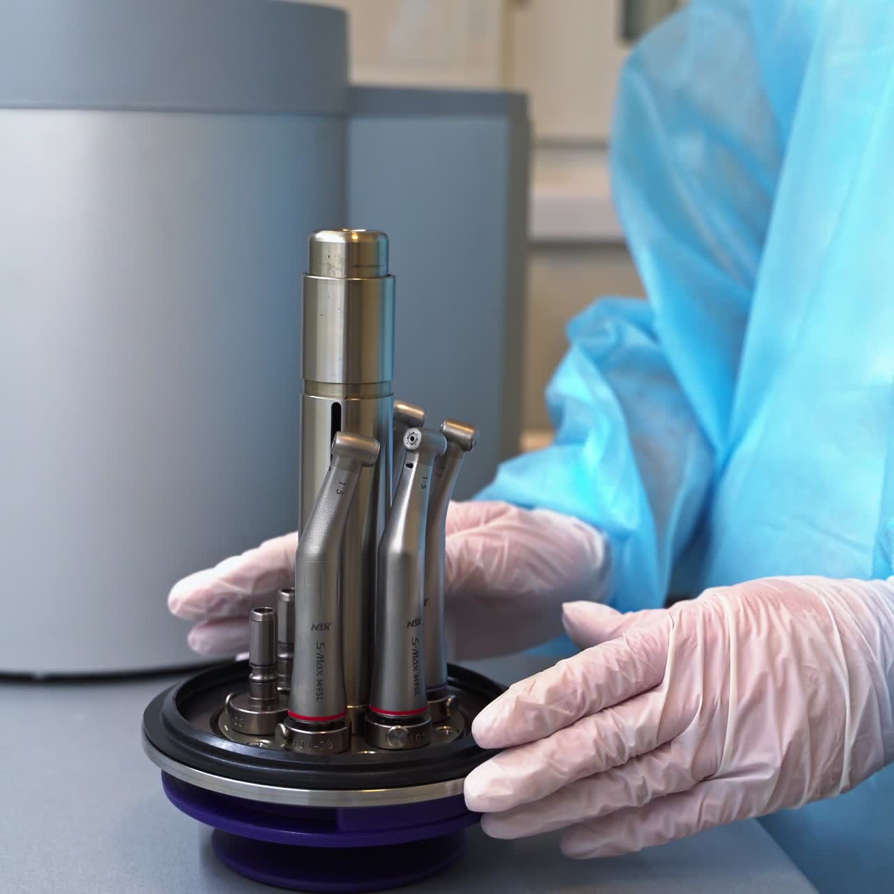 Gloved hands put the nozzles from dental machine into a special holder. Keeping and management of dental care instruments. Close up