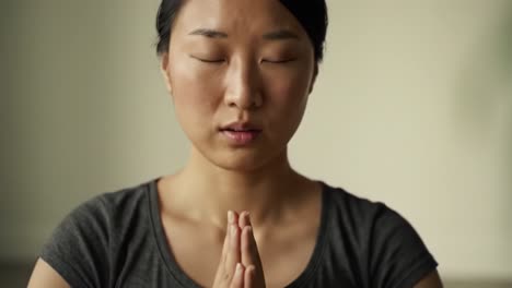 a tranquil moment of reflection: a close-up of a serene individual in a meditative state with eyes closed, surrounded by soft greenery and natural light
