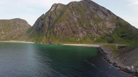 Aerial-shot-of-remote-Lofoten-Sandvika-beach-in-Noway-surrounded-by-steep-cliffs