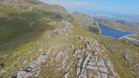 toma aérea volando sobre crestas rocosas en la montaña de la mesa en ciudad del cabo, sudáfrica