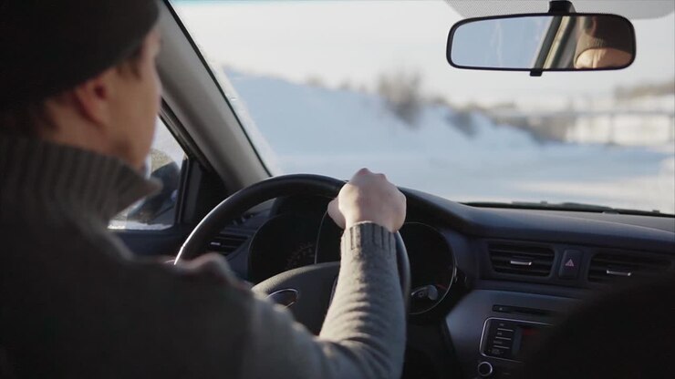 Uomo alla guida di un'auto in inverno