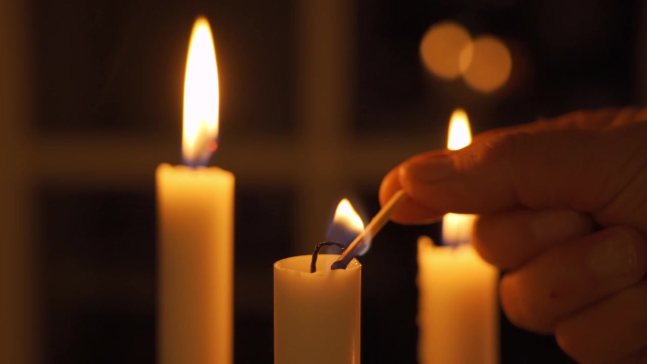 Una delle tre candele viene accesa con un fiammifero con un sottile movimento di dolly.