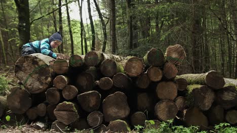 niño trepando sobre troncos en el bosque en un día nublado